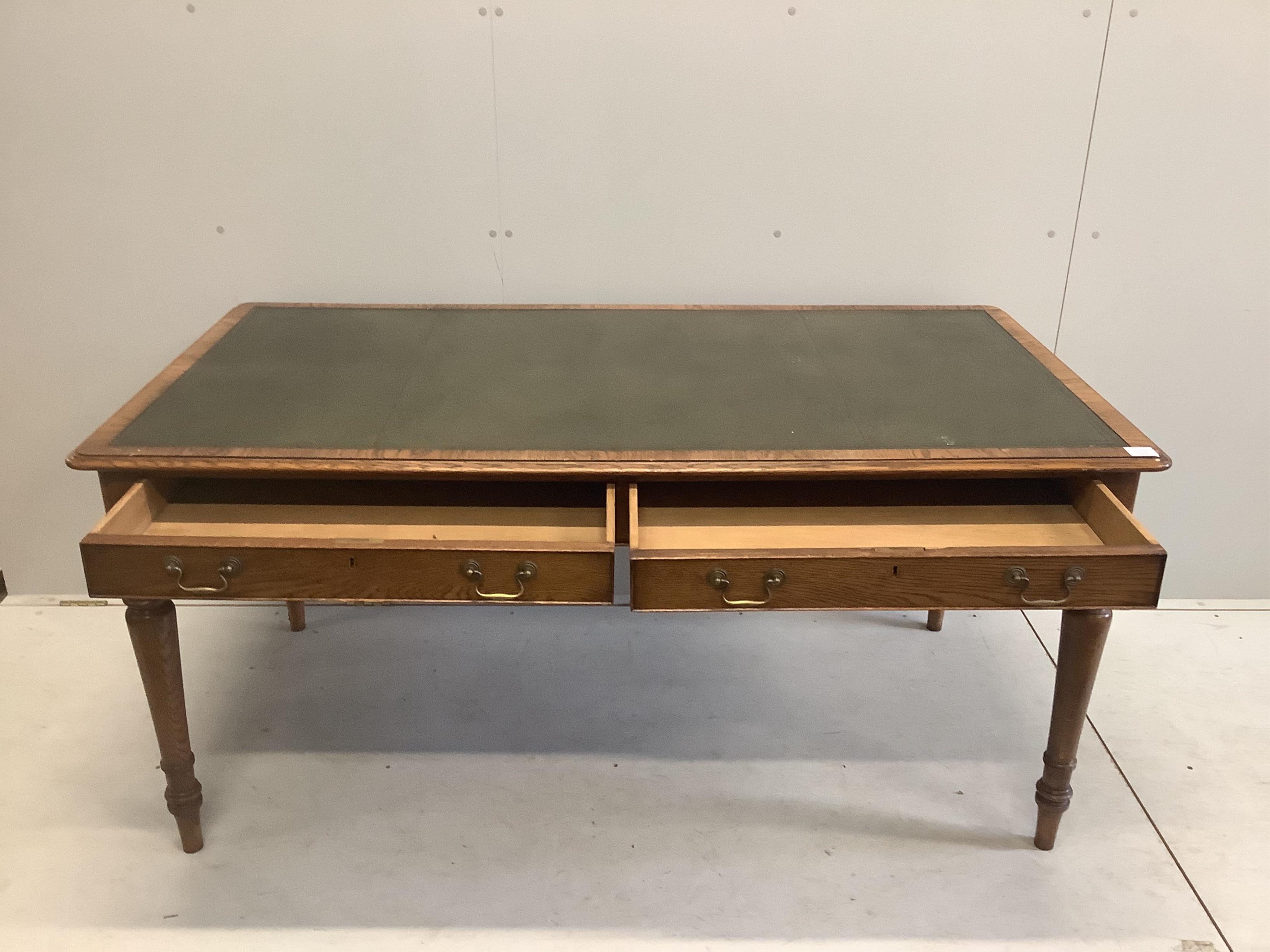 A reproduction Victorian style oak two drawer writing table, width 160cm, depth 84cm, height 76cm. Condition - good